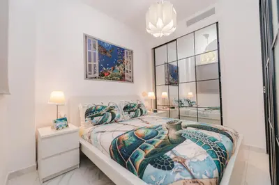 a bedroom with a king sized bed and a chandelier at Sea Escape Casa Tortuga @ Cana Rock 1 Bdrm Bliss in Punta Cana