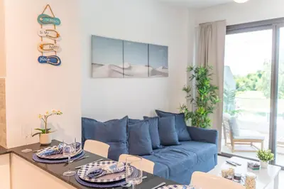 a living room with a blue couch and a table at Sea Escape Casa Tortuga @ Cana Rock 1 Bdrm Bliss in Punta Cana