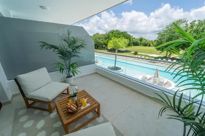 a living room with a view of a swimming pool at Sea Escape Casa Tortuga @ Cana Rock 1 Bdrm Bliss in Punta Cana