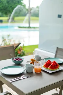 a table with plates of food and fruit on it at Aqua Fam Swim out Suite - Pool @ Cana Rock G 117 in Punta Cana