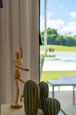 a wooden doll standing on a table next to a cactus at Directo piscina jardín terraza @ Cana Rock in Punta Cana