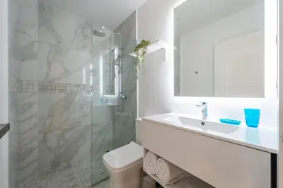 a white bathroom with a sink and a shower at Directo piscina jardín terraza @ Cana Rock in Punta Cana