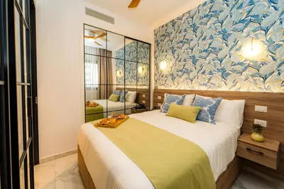 a bedroom with a large bed with a blue and white wall at Aqua Luxe @ Cana Rock terrace to pool access E-105 in Punta Cana