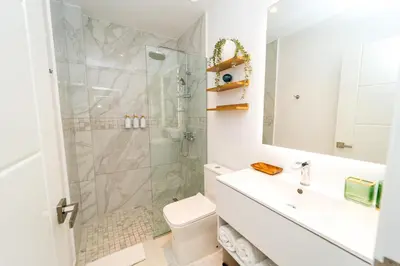a bathroom with a shower and a toilet and a sink at Aqua Luxe @ Cana Rock terrace to pool access E-105 in Punta Cana
