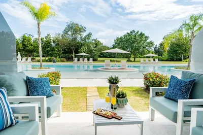 a patio with chairs and a swimming pool at Aqua Luxe @ Cana Rock terrace to pool access E-105 in Punta Cana
