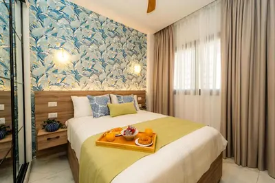 a bedroom with a bed with a tray of food on it at Aqua Luxe @ Cana Rock terrace to pool access E-105 in Punta Cana