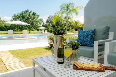 a table with a tray of food and a bottle of wine at Aqua Luxe @ Cana Rock terrace to pool access E-105 in Punta Cana