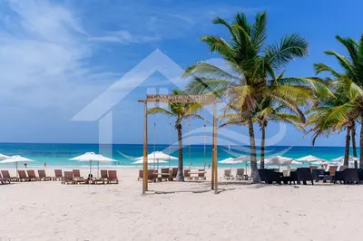 a beach with chairs and umbrellas and the ocean at Single Loft Best Pool Views! Cana Rock Star G-205 in Punta Cana