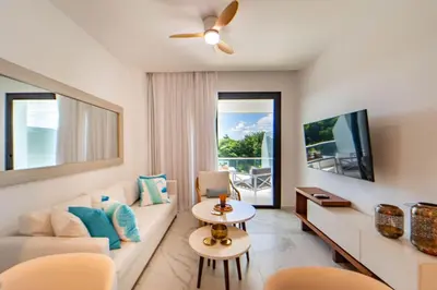 a living room with a couch and a tv at Single Loft Best Pool Views! Cana Rock Star G-205 in Punta Cana