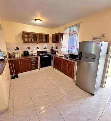 a large kitchen with a stainless steel refrigerator at Cozy 2 Bedroom Apartment Boca Chica in Boca Chica