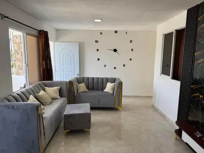 a living room with a couch and a clock on the wall at Apartmento Las Palmeras 1 A1 in Vicente Noble