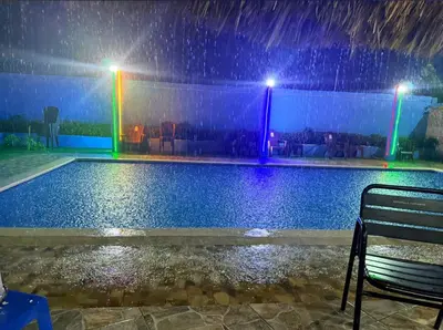a pool in the rain with a bench and lights at Apartmento Las Palmeras 1 A1 in Vicente Noble