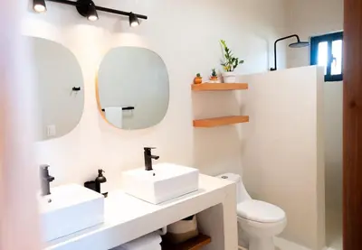 a bathroom with two sinks and a toilet at Private Villa-Infinity Pool-26 guests capacity-14 King Size Beds-8 bedrooms-8 and half baths in Cabrera