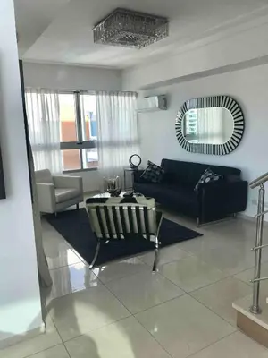 a living room with a black couch and a mirror at Eclectic 3 levels and 5 bedrooms penthouse in Santo Domingo