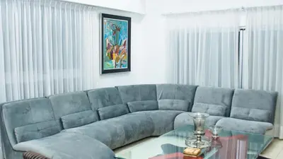 a living room with a blue couch and a glass table at Eclectic 3 levels and 5 bedrooms penthouse in Santo Domingo