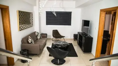 a living room with a couch and a television at Eclectic 3 levels and 5 bedrooms penthouse in Santo Domingo