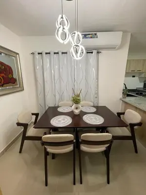 a dining room table with chairs and a chandelier at Romana Residence Vacationing Apartment in Cumayasa Kilómetros Diez