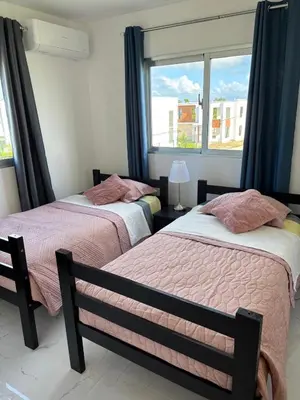 two beds in a room with a window at Villa Carpe Diem in Punta Cana