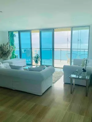 a living room with white furniture and a view of the ocean at Vista al mar Hab Privada Larimar, Malecon Santo D in Santo Domingo