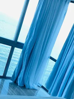 a window with blue curtains in a cruise ship at Vista al mar Hab Privada Larimar, Malecon Santo D in Santo Domingo