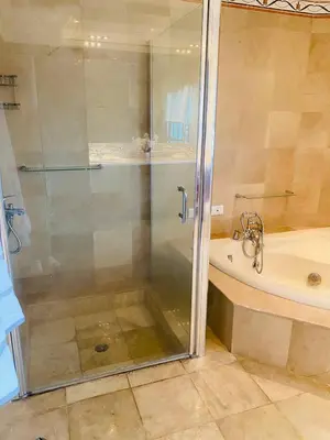 a shower with a glass door next to a bath tub at Vista al mar Hab Privada Larimar, Malecon Santo D in Santo Domingo