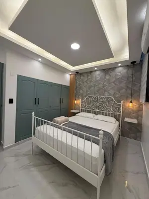 a bedroom with a large bed and green cabinets at Confortable apartamento en Villa Olga in Santiago de los Caballeros