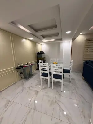 a living room with a table and chairs on a marble floor at Confortable apartamento en Villa Olga in Santiago de los Caballeros