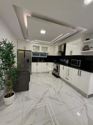 a large kitchen with white cabinets and a marble floor at Confortable apartamento en Villa Olga in Santiago de los Caballeros