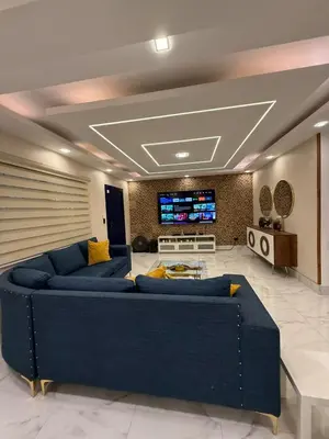 a living room with two blue couches and a tv at Confortable apartamento en Villa Olga in Santiago de los Caballeros