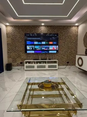 a lobby with a large television and a glass table at Confortable apartamento en Villa Olga in Santiago de los Caballeros