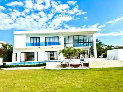 a large white house with a lawn in front of it at 8 BR Grand Villa in Oceanfront Comm Sosua Ocean Vill in Sosúa
