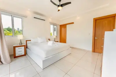 a white bedroom with a bed and a window at 5bd Villa in Oceanfront Community Sosua Ocean Village in Sosúa
