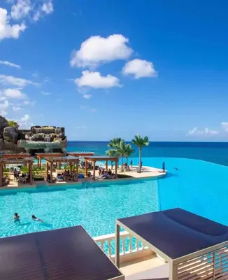 a resort swimming pool with the ocean in the background at Villa Solana in Oceanfront Com Sosua Ocean Village in Sosúa