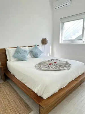 a bedroom with a bed with white sheets and a window at Villa Solana in Oceanfront Com Sosua Ocean Village in Sosúa