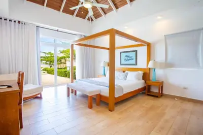 a bedroom with a canopy bed and a large window at Ocean Haven Oceanfront in Sosua Ocean Village in Sosúa