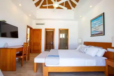 a bedroom with a bed and a desk and a television at Ocean Haven Oceanfront in Sosua Ocean Village in Sosúa