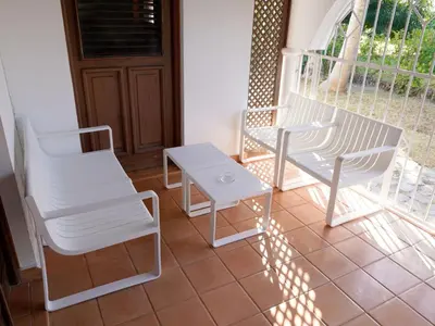 a porch with two chairs and a table at Villa silenziosa e sicura al centro di Las Galeras in Las Galeras
