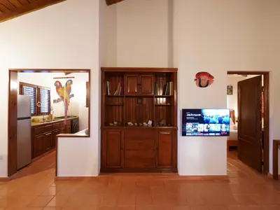 a kitchen with wooden cabinets and a television on a wall at Villa silenziosa e sicura al centro di Las Galeras in Las Galeras