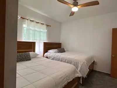 two beds in a bedroom with a ceiling fan at Villa kiyana-14 pax, 5min de la playa en Las Galeras in Las Galeras