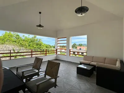 a living room with a couch and chairs and a balcony at Villa kiyana-14 pax, 5min de la playa en Las Galeras in Las Galeras