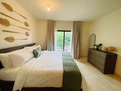 a bedroom with a bed and a dresser and a mirror at Marien Residences 221 Garden & Partial Ocean View Condo in Puerto Plata