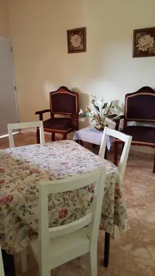 a dining room with a table and two chairs and a table with a floral table at Apartamentos Nuevo Amanecer in Río San Juan