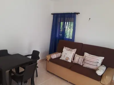 a living room with a brown couch and a table at Apartamentos Nuevo Amanecer in Río San Juan