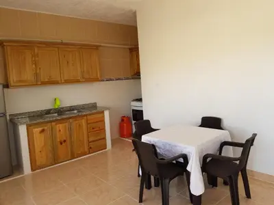 a kitchen with a table and chairs in a kitchen at Apartamentos Nuevo Amanecer in Río San Juan