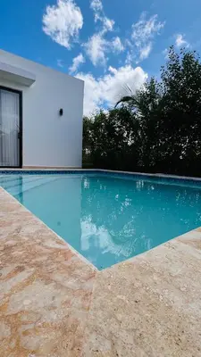 a swimming pool in front of a white building at Villa YOSYMART Poolside Retreat private WIFI Luxury BBQ side in Punta Cana