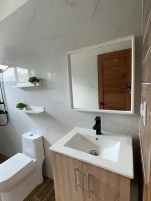 a bathroom with a sink and a toilet and a mirror at Villa YOSYMART Poolside Retreat private WIFI Luxury BBQ side in Punta Cana