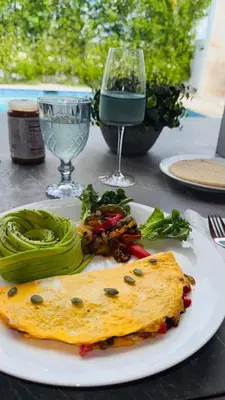 a white plate with a omelet and vegetables on a table at Villa YOSYMART Poolside Retreat private WIFI Luxury BBQ side in Punta Cana