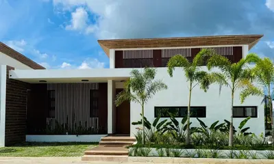 a house with palm trees in front of it at Villa YOSYMART Poolside Retreat private WIFI Luxury BBQ side in Punta Cana