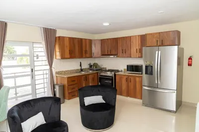 a kitchen with wooden cabinets and a stainless steel refrigerator at La Isla Royal - Abismo Celeste in Miches