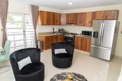 a kitchen with two black chairs and a refrigerator at La Isla Royal - Abismo Celeste in Miches